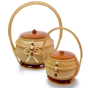 Peut inclure: Deux paniers tressés avec couvercles et poignées en bois. Le plus grand panier a un nœud décoratif et une fermeture à bouton. Le plus petit panier a un design similaire. Les deux paniers sont marron clair et beige.