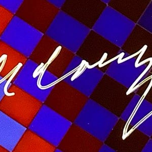 May include: Abstract design featuring a checkered pattern in red, blue, and dark brown. The word "bud" is written in a flowing, white script across the image. The background is a repeating square pattern.
