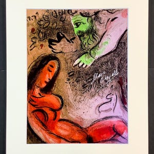 Può includere: Un'opera d'arte incorniciata con un'illustrazione astratta colorata. L'opera raffigura una donna in rosso, una figura con il volto verde e un cavallo bianco. La firma dell'artista è visibile in basso a destra. L'opera è montata in un passe-partout bianco.
