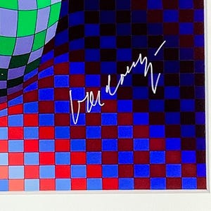 May include: Abstract art print featuring a vibrant, checkered pattern in shades of blue, red, and green. The artwork includes a signature in white. The design is framed in a white border.