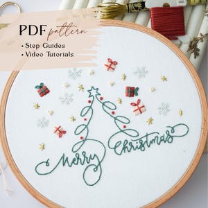 May include: Embroidered Christmas design on white fabric in a wooden hoop. The design includes a Christmas tree, the words "Merry Christmas", snowflakes, and gift boxes. The text "PDF pattern" is at the top.