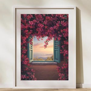 Könnte beinhalten: Ein gerahmter Kunstdruck zeigt ein offenes Fenster mit türkisfarbenen Fensterläden, umgeben von leuchtend pinkfarbenen Bougainvillea-Blüten. Der Blick durch das Fenster zeigt einen Sonnenuntergang über dem Meer und der Küste. Der Text Maison-MehyArt steht unten.