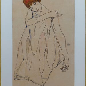 Könnte beinhalten: Bleistiftskizze einer sitzenden Figur mit rotem Stirnband, verschränkten Armen und drapiertem Stoff. Das Kunstwerk befindet sich auf beigefarbenem Papier, mit der Signatur des Künstlers und der Editionsnummer. Der Stil erinnert an den Expressionismus des frühen 20. Jahrhunderts.