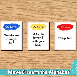 May include: Three white cards with colorful text on a wooden surface. Each card has a different instruction: "Waddle like a penguin to P," "Make the letter T with your body," and "Stomp to G." The text "Move & Learn the Alphabet" is at the bottom.