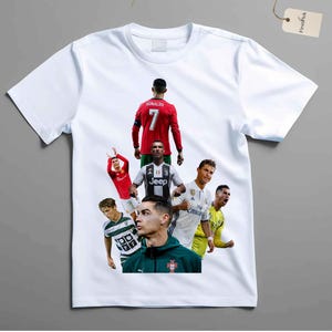May include: White t-shirt featuring multiple images of a soccer player in various uniforms. The player is wearing a red jersey with the number 7, a Juventus jersey, and a white Real Madrid jersey. The shirt has a crew neck.