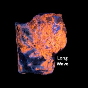 May include: A glowing rock formation with orange and blue hues against a black background. The text "Long Wave" is displayed in white. The rock's surface has a textured appearance.