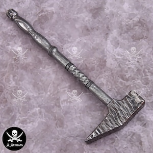Pode incluir: Um martelo artesanal em aço Damasco com cabo e cabeça texturizados. O martelo apresenta um padrão único e uma extremidade pontiaguda. O cabo tem um design decorativo. O martelo é uma ferramenta.