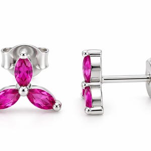 May include: A pair of silver stud earrings featuring three marquise-cut vibrant pink stones arranged in a clover-like cluster. Each earring includes a post back mechanism, showcasing a polished metallic finish and faceted gemstone surfaces.