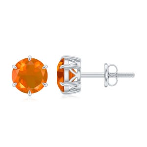 May include: A pair of stud earrings featuring round, orange gemstones set in a silver metal. The gemstones have a fiery, translucent appearance. The earrings are displayed against a white background.