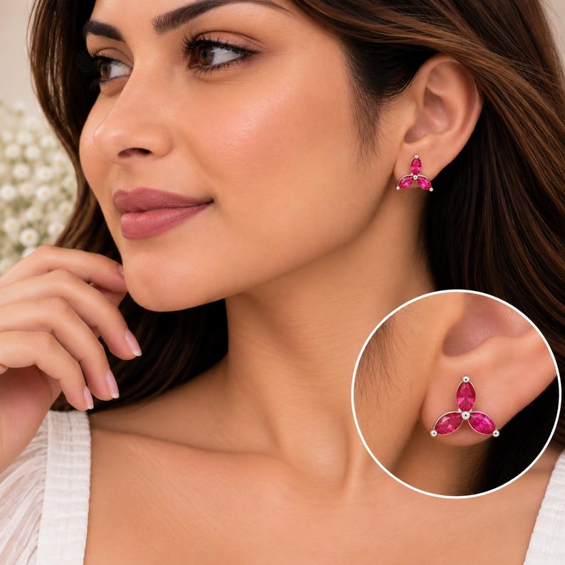 May include: A stud earring featuring three marquise-cut fuchsia pink stones arranged in a floral-like cluster. The stones are set in a silver-toned metal frame, creating a symmetrical design that sits flush against the earlobe for a refined look.