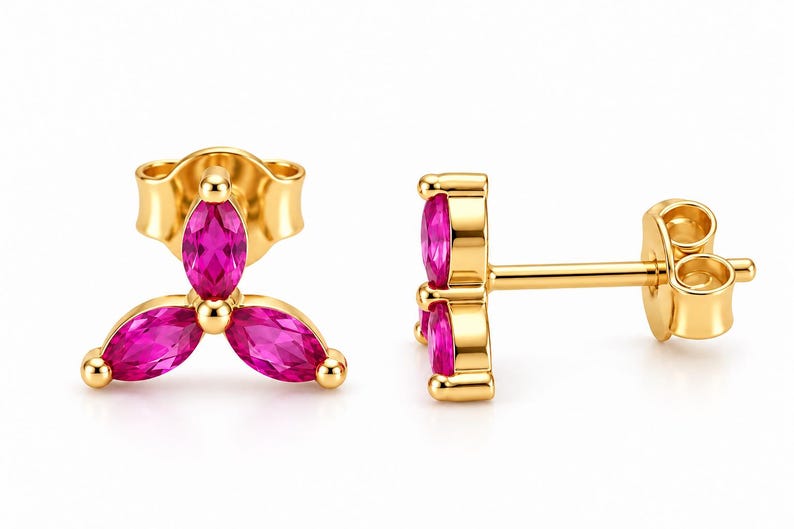 May include: A pair of gold stud earrings, each featuring three marquise-cut vibrant pink stones arranged in a floral cluster pattern. The earrings include gold posts and matching butterfly-style friction backs for secure attachment to the earlobe.