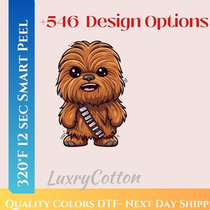 May include: A cartoon illustration of a brown, furry creature with large eyes and a bandolier. The image includes the text "+546 Design Options", "320°F 12 SEC SMART PEEL", and "LuxryCotton". The bottom banner reads "QUALITY COLORS DTF- NEXT DAY SHIPPING- BEST PRICE".