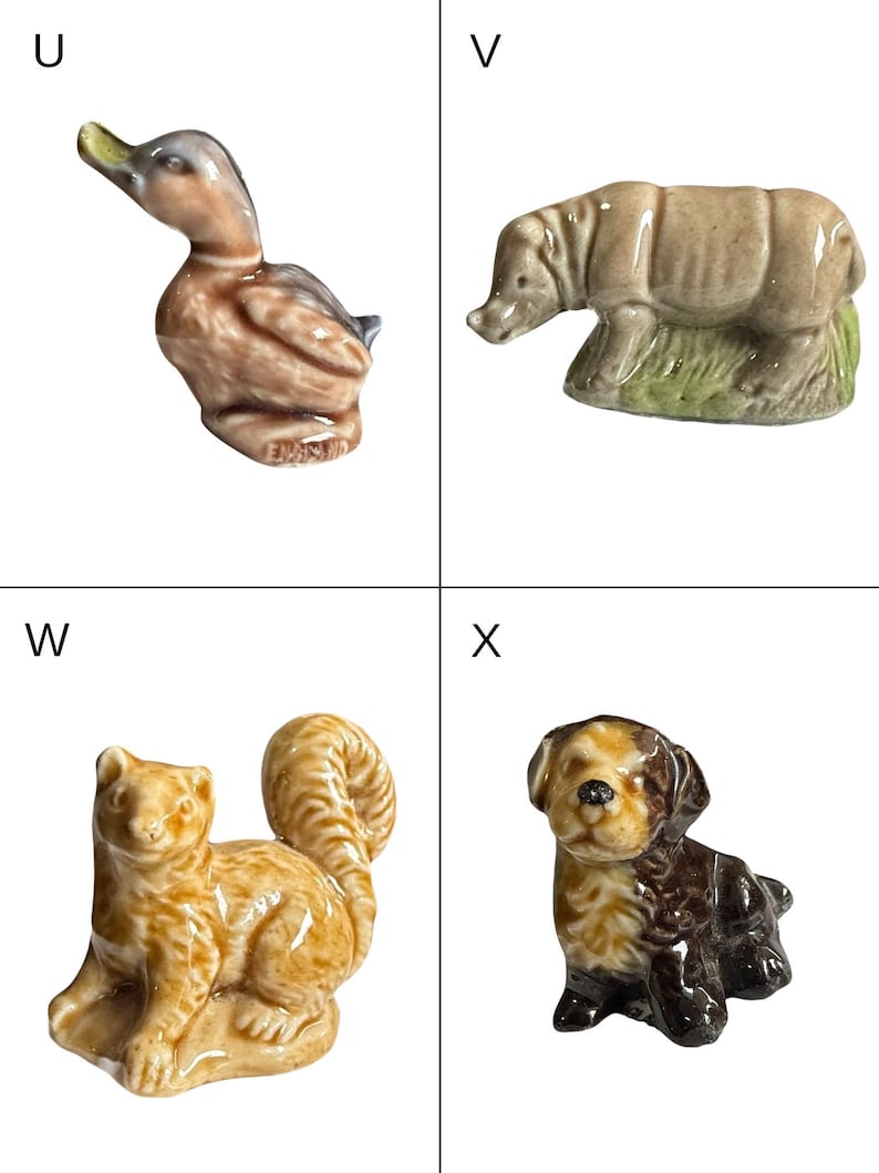 May include: A collection of four small ceramic animal figurines. Includes a duck, a rhinoceros, a squirrel, and a puppy. The duck is brown and gray, the rhino is tan, the squirrel is tan and orange, and the puppy is brown and tan.