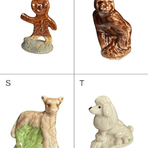 May include: Four small ceramic figurines: a gingerbread man, a monkey, a lamb, and a poodle. The gingerbread man is brown with a smiling face. The monkey is brown and seated. The lamb is tan with green accents. The poodle is white.