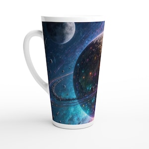Puede incluir: Una taza de cerámica blanca para café con leche que presenta un diseño espacial vibrante que envuelve toda la superficie. El gráfico muestra un planeta grande con anillos brillantes, una luna más pequeña y estrellas dispersas sobre un fondo.