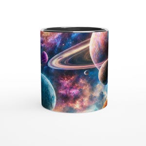 Peut inclure: Un mug cylindrique en céramique orné d'un imprimé sur le thème de l'espace. Le motif représente une nébuleuse colorée avec des nuages tourbillonnants de rose, de violet et de bleu, ainsi que plusieurs planètes, dont une avec des anneaux dorés.