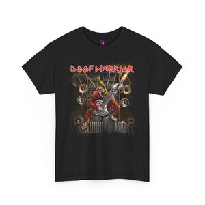 May include: Black t-shirt with the red and white text "DAAF WARRIOR". The graphic shows a warrior playing a guitar, set against a backdrop of speakers and mechanical components. The warrior is dressed in red.