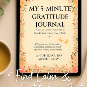 Puede incluir: Una tableta digital muestra un diario titulado "MY 5-MINUTE GRATITUDE JOURNAL". La portada es de color crema con detalles florales y texto. El diario promete autocuidado, positividad y paz interior. También se ve una taza de té.