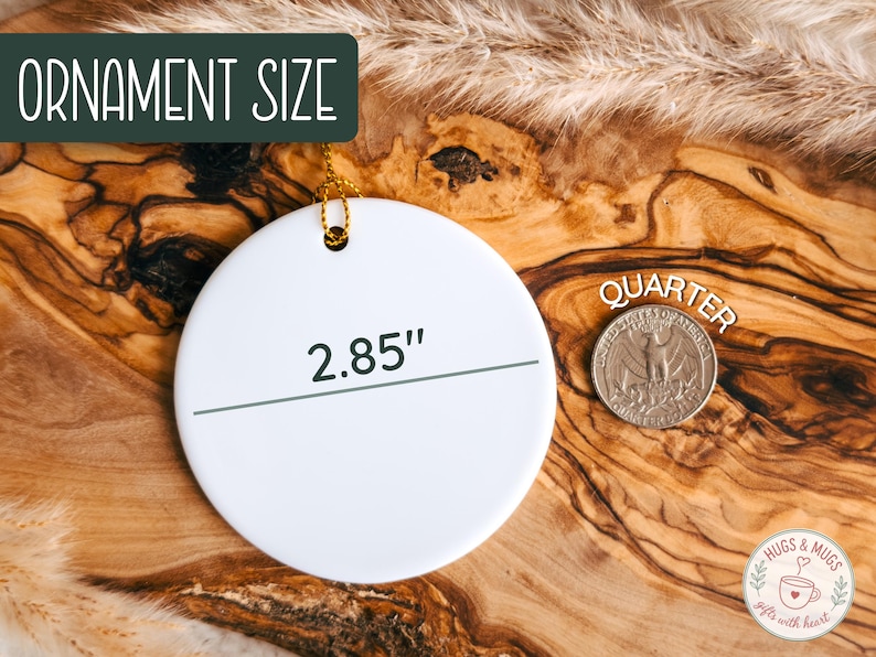 May include: A white, round ornament with a gold string for hanging. The ornament is 2.85 inches in diameter. The text "Ornament Size" is in a green box. A quarter coin is next to the ornament.