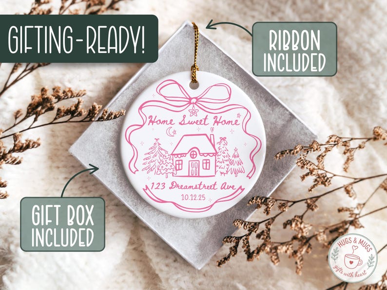 May include: White ceramic ornament with a pink house design, text reading "Home Sweet Home" and "123 Dreamstreet Ave 10.12.25". Includes a gold ribbon for hanging. Comes in a gift box.