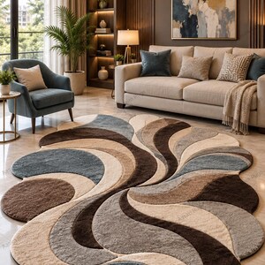 May include: A large, irregularly shaped area rug featuring a textured, multi-layered design with overlapping curved segments in shades of dark brown, light beige, grey, and slate blue, creating a dynamic, flowing pattern across the floor.