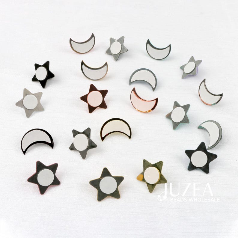 Puede incluir: Un surtido de hallazgos de joyer&iacute;a en forma de estrella y media luna. Los hallazgos son de varios colores, incluyendo negro, gris y oro rosa, con un centro circular blanco. La imagen est&aacute; sobre un fondo blanco.