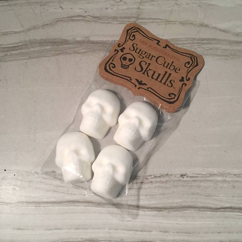 One bag of 4 skull shaped sugar cubes on tile surface. Kraft hangtag with DemBones Original Sugar Cube Skulls.