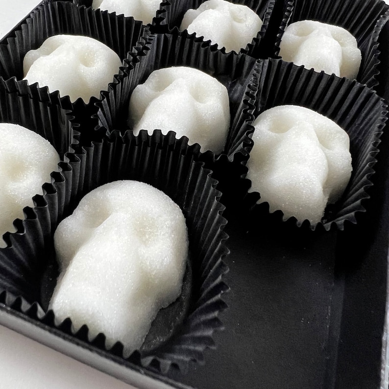 Close up of corner of the black candy box and black candy cups with skull sugar cubes.