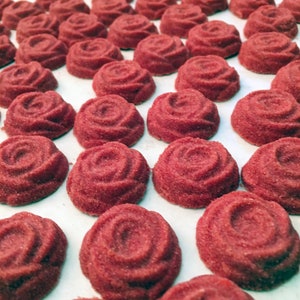 Entire image is filled with red rose shaped sugar cubes on a white background