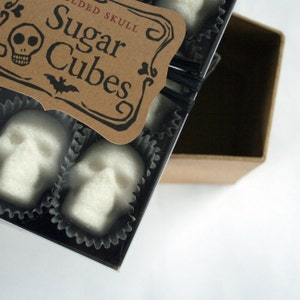 Close up of corner of gift box featuring skull shaped sugar cubes, Kraft label reads Sugar Cubes