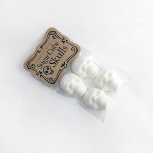 One bag of skull sugar cubes on white background, Kraft hangtag with DemBones Original Sugar Cube Skulls, 4 skulls in bag