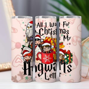 May include: A set of three skinny tumblers with a light pink background and a repeating pattern of candy canes and hearts. Each tumbler features a cartoon illustration of characters in Santa hats with the text "All I Want For Christmas Is My Hogwarts Letter."