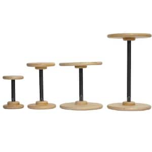 May include: Four wooden display stands of varying heights. Each stand has a round, light-colored wooden top and base, connected by a black metal pole. The stands are arranged from shortest to tallest, ideal for showcasing items.