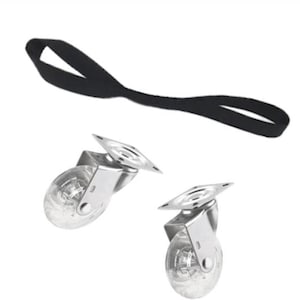 May include: Two clear caster wheels with silver metal frames and a black strap. The wheels have a transparent design, and the strap is a simple loop. The items are set against a white background.