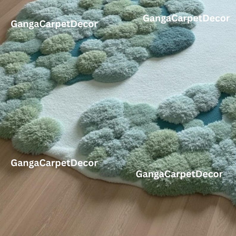 Puede incluir: Una alfombra con dise&ntilde;o de paisaje. La alfombra presenta una base blanca con &aacute;reas afelpadas en tonos verdes y azules, que se asemejan a un bosque o paisaje. El texto "GangaCarpetDecor" es visible.