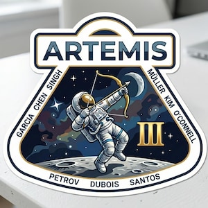 May include: A white ceramic mug with a black handle and the text "But First, Coffee" in a handwritten style. The mug is on a white surface. The mug is approximately 4 inches tall.