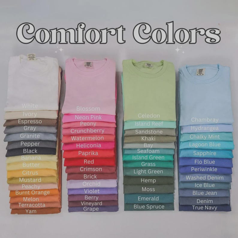 May include: A display of Comfort Colors t-shirts in a range of shades, from white and pink to green and blue. Each stack of folded shirts is labelled with a colour name, like "Blossom" and "Chambray".