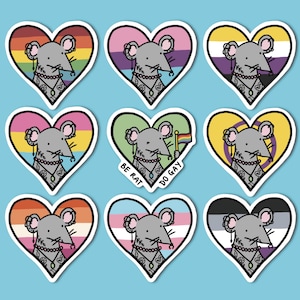 May include: A selection of heart-shaped stickers with a cartoon rat wearing a necklace, on a light blue backdrop. Each heart showcases a different LGBTQ+ flag design. The words "LGBTQ+ RAT" and "STICKERS" are written in colourful letters.