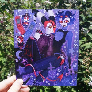 May include: A rectangular art print featuring a stylized illustration of two animated characters with red and blue color schemes. The artwork includes small flip phones, plush toys, stars, and heart symbols set against a deep purple background.