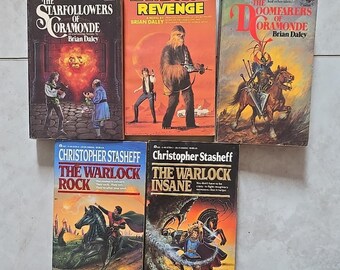May include: A collection of vintage science fiction and fantasy paperback books. Titles include "The Starfollowers of Coramonde", "Han Solo's Revenge", "The Doomfarers of Oramonde", "The Warlock Rock", and "The Warlock Insane". The covers feature illustrations.