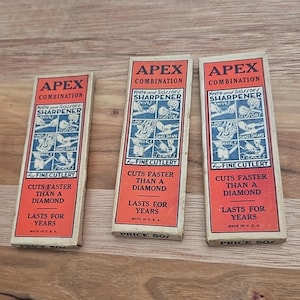 May include: Three vintage Apex Combination knife and scissors sharpeners. Each box has a red top with white text and illustrations, including the phrases "Cuts Faster Than a Diamond" and "Lasts for Years."