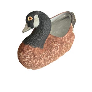 May include: A set of three ceramic mugs with a speckled, matte finish. The mugs are in shades of cream, light gray, and dark gray. Each mug has a simple, minimalist design, perfect for coffee or tea.