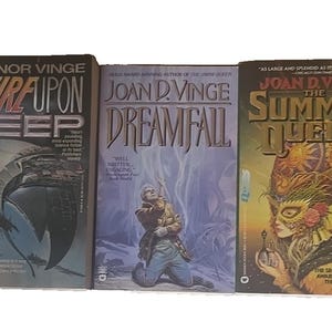 May include: Three science fiction novels by Vernor Vinge and Joan D. Vinge. The books feature colorful covers with titles like "A Fire Upon the Deep," "Dreamfall," and "The Summer Queen." The covers display illustrations of futuristic scenes and characters.