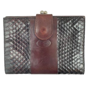 May include: A rectangular wallet featuring dark brown snakeskin-textured panels on the sides and a smooth, solid dark brown leather center strap. The strap includes a metal kiss-lock closure at the top and an embossed oval logo with the letters FF.