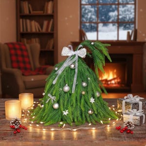 May include: A green Christmas tree-shaped decoration with silver ornaments and a white bow. The tree is decorated with silver ornaments and star-shaped decorations. The tree is surrounded by a string of lights, candles, and wrapped gifts.