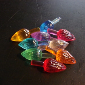 Può includere: Assortimento di lampadine di Natale in plastica colorate in varie tonalità di rosso, arancione, giallo, verde, blu e viola.