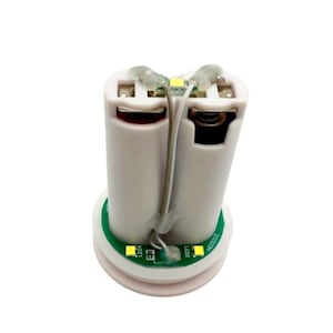 Może przedstawiać: Zbliżenie na białą świecę LED zasilaną bateriami z zieloną płytką drukowaną. Płytka drukowana ma dwie diody LED oznaczone jako "LED1" i "LED2" oraz tekst "NO001D".