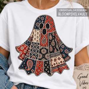 May include: A white t-shirt featuring a central graphic of a ghost composed of various patchwork fabric patterns in shades of red, navy blue, black, and cream. The ghost has three black oval-shaped eye and mouth openings. The text ORIGINAL DESIGNER BLOOMPIXELVAULT is visible in the upper right corner.