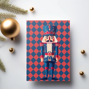 May include: A Christmas card with a nutcracker soldier design. The card has a red and blue diamond pattern background. Gold baubles and evergreen branches surround the card, creating a festive holiday theme.