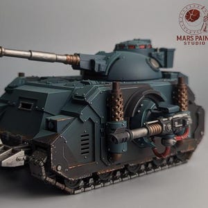 May include: A teal and brown model tank with a long gun barrel and detailed mechanical features. The tank has a textured finish and visible tracks. The image includes the "Mars Paint Studio" logo in the background.